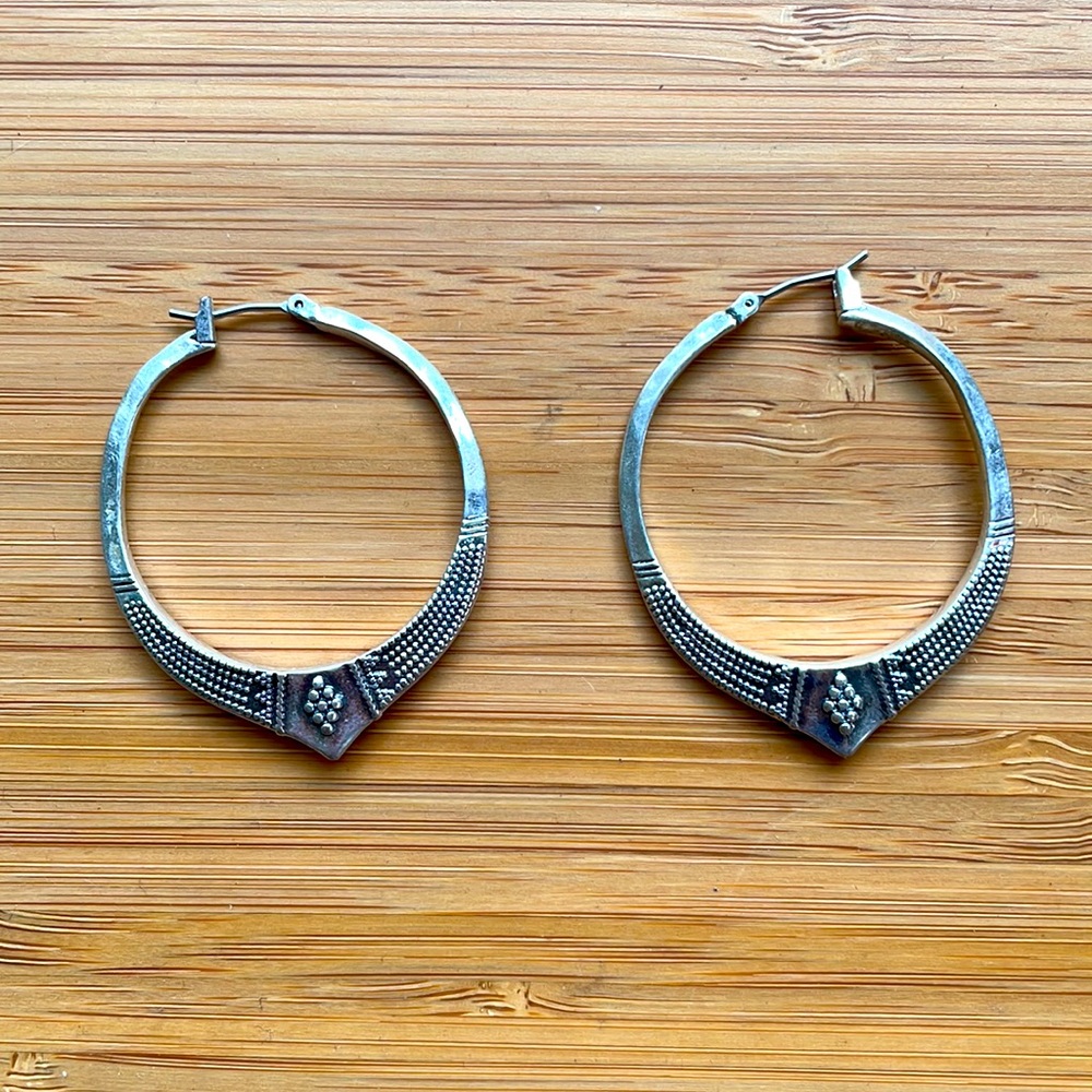 Silver hoop earring with embellished bottom and latch closure